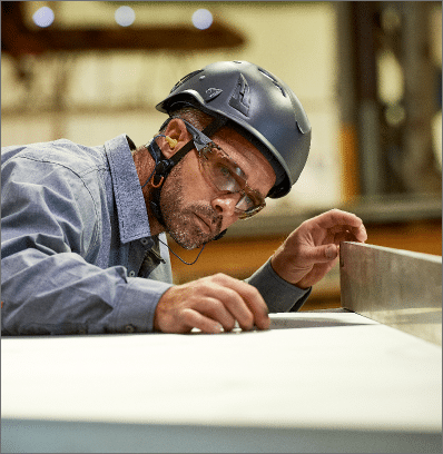 Homme avec des équipements de protection regardant son plan de travail