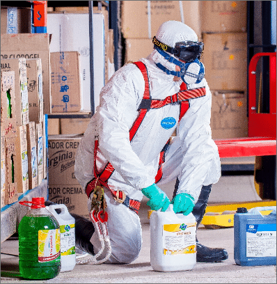 Homme en équipement de protection manipulant des produits chimiques